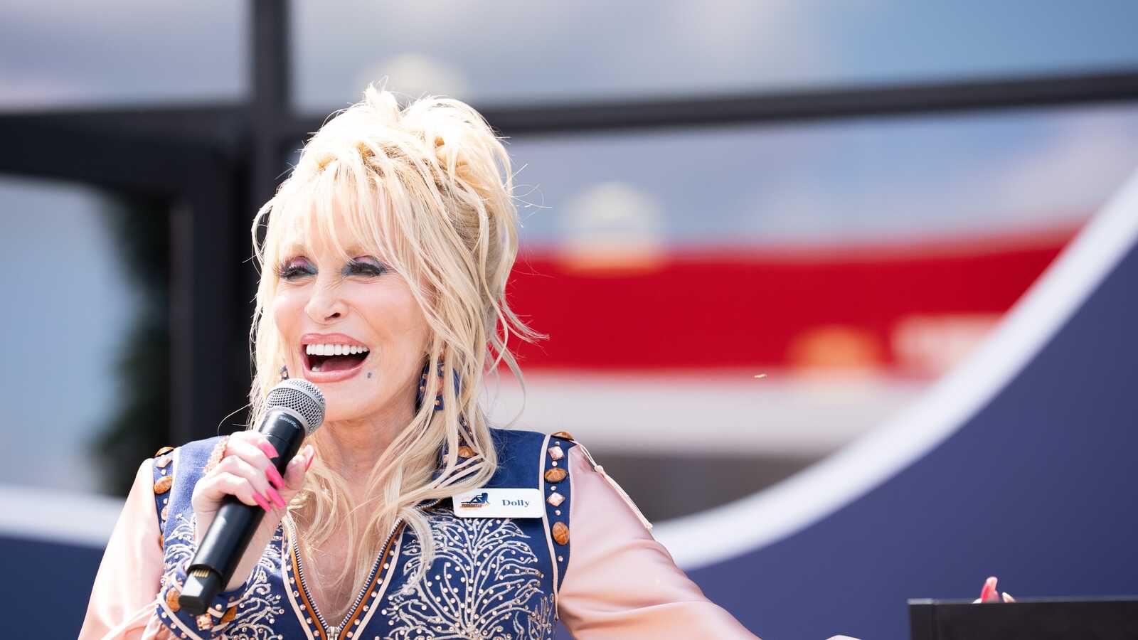 https://www.yardbarker.com/media/b/8/b84390c2ad61ade6e49a73a7e78b9c68dd004db9/thumb_16x9/dolly-parton-speaks-crowd-during-grand-opening.jpg